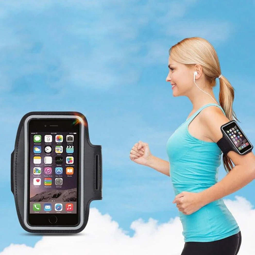 Woman running with a smartphone in an armband against a blue sky background