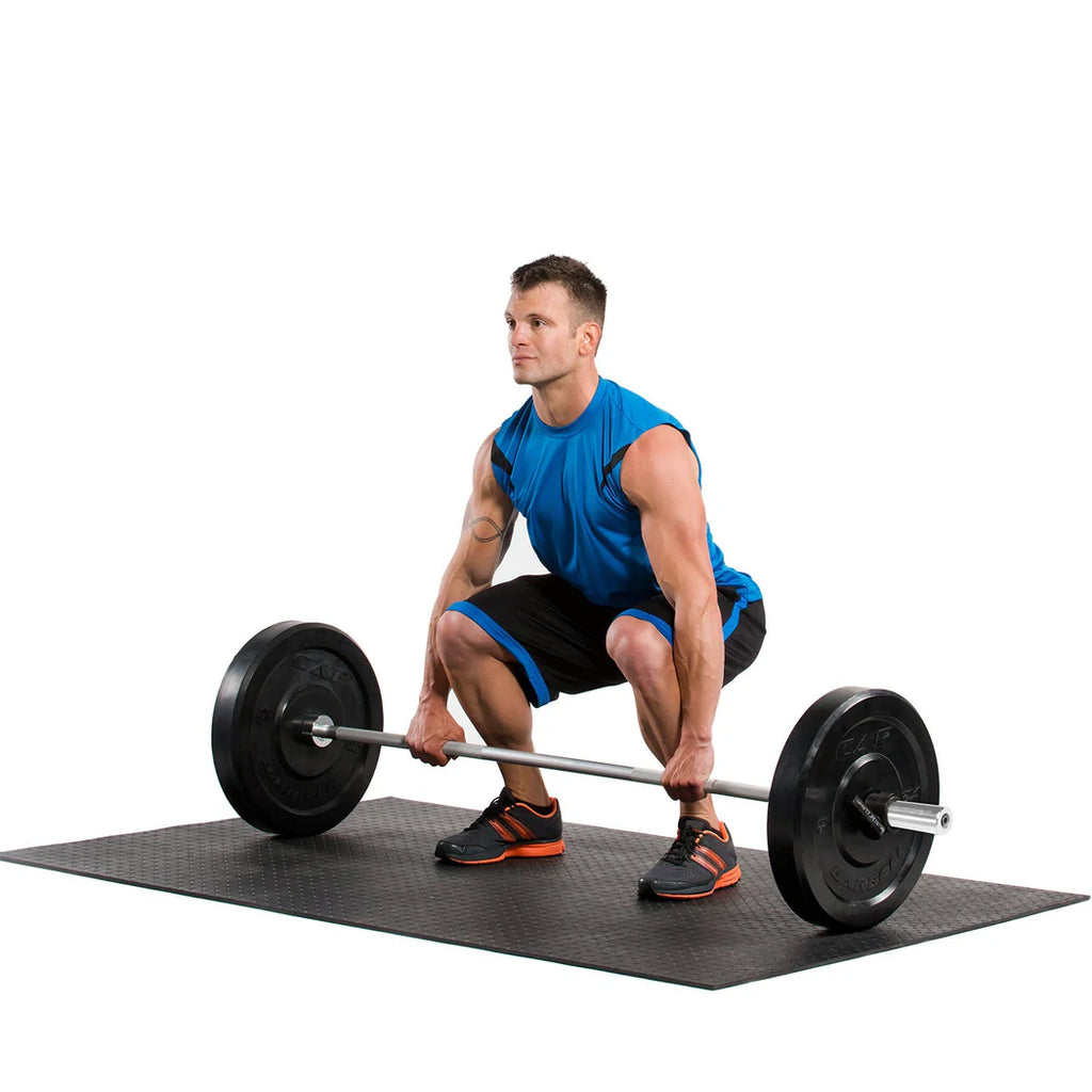 Man performing a barbell squat on a black mat with a white background