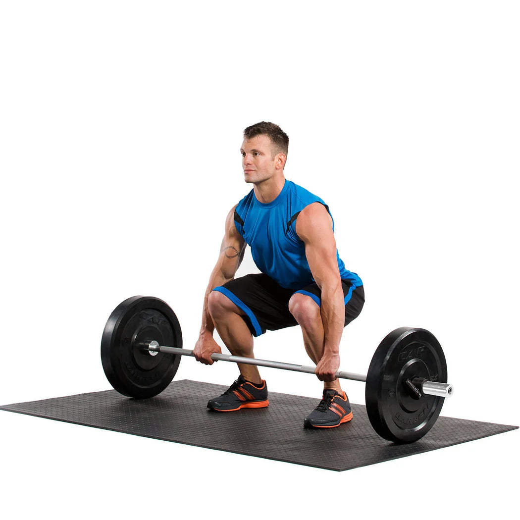 Man performing a barbell squat on a black mat with a white background