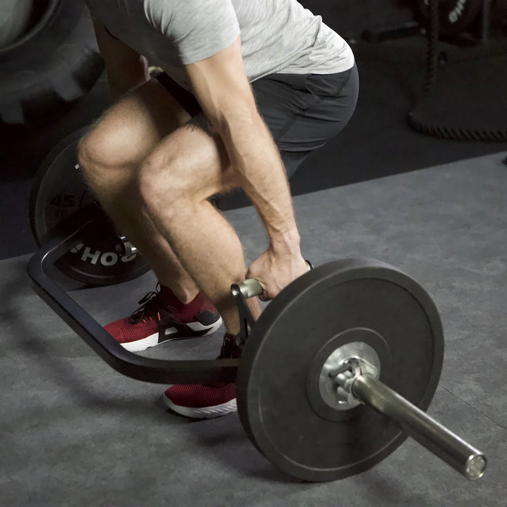 Person lifting a barbell in a gym setting
