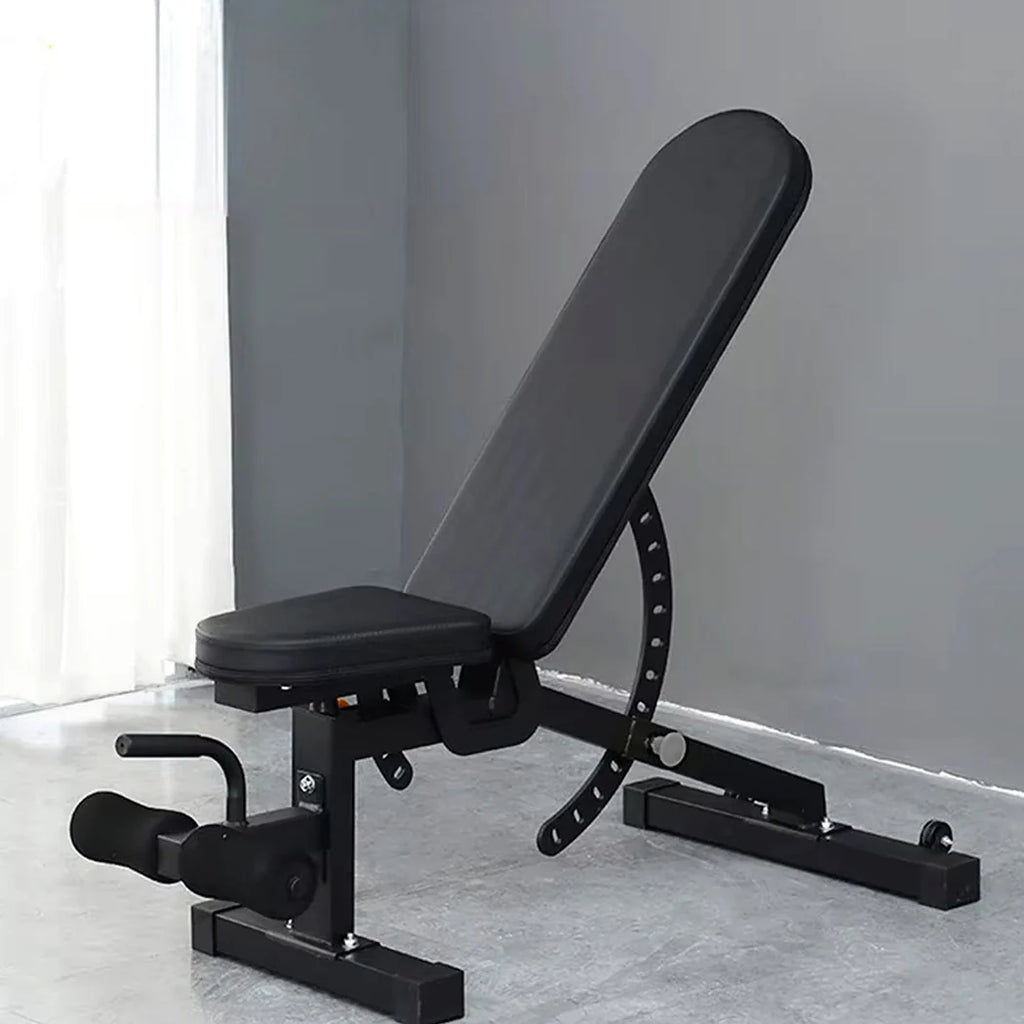 Black adjustable weight bench in a room with a gray wall and white floor.