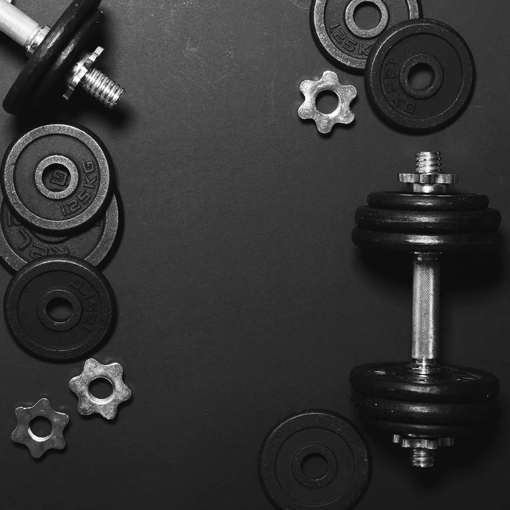 Black dumbbells and weight plates on a dark background