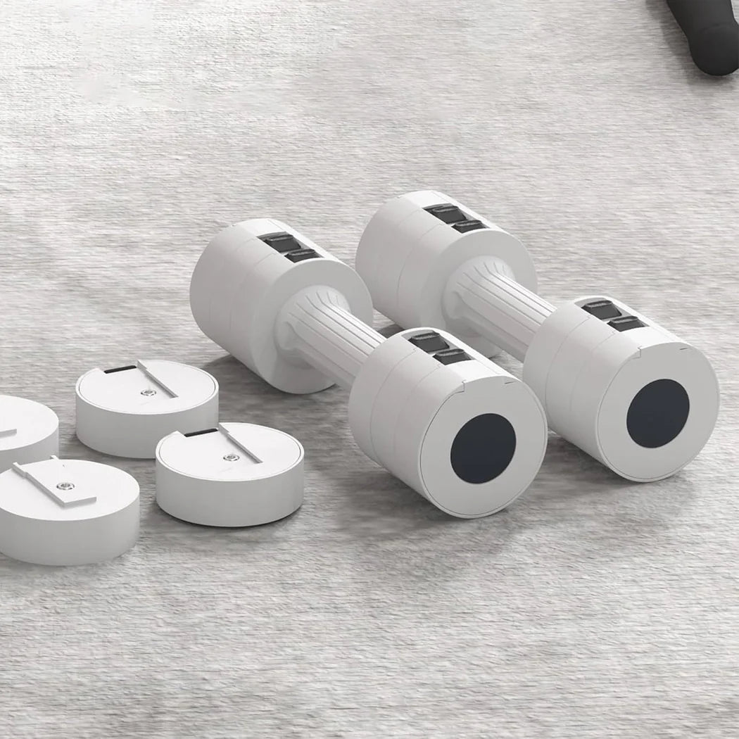 Set of white dumbbells with black weight plates on a gray surface