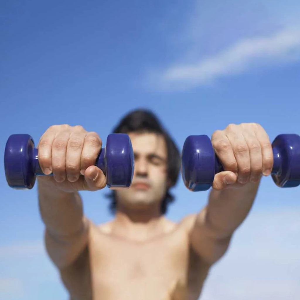 Man lifting purple dumbbells against a blue sky