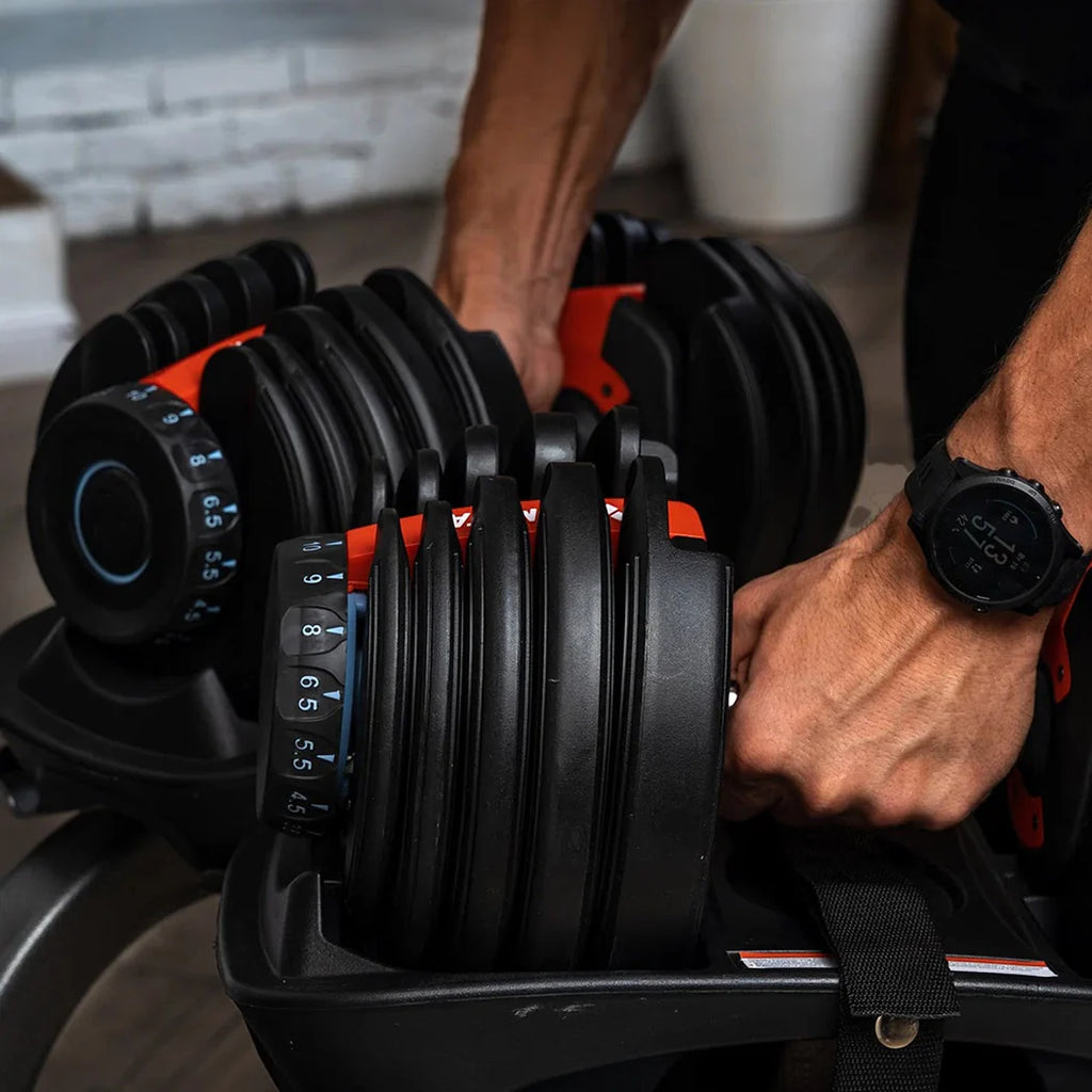 Person holding a set of adjustable dumbbells with a blurred background