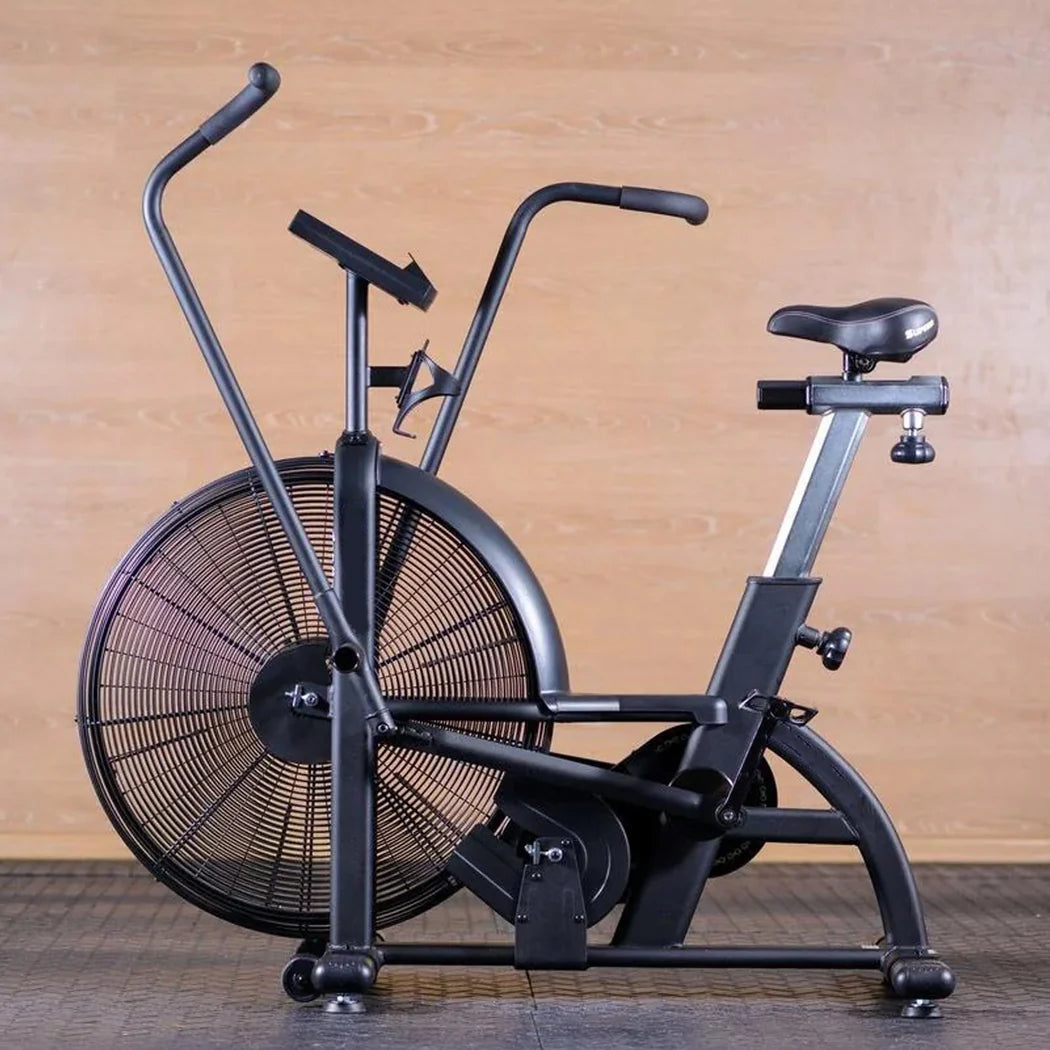 Black exercise bike with fan on a wooden floor