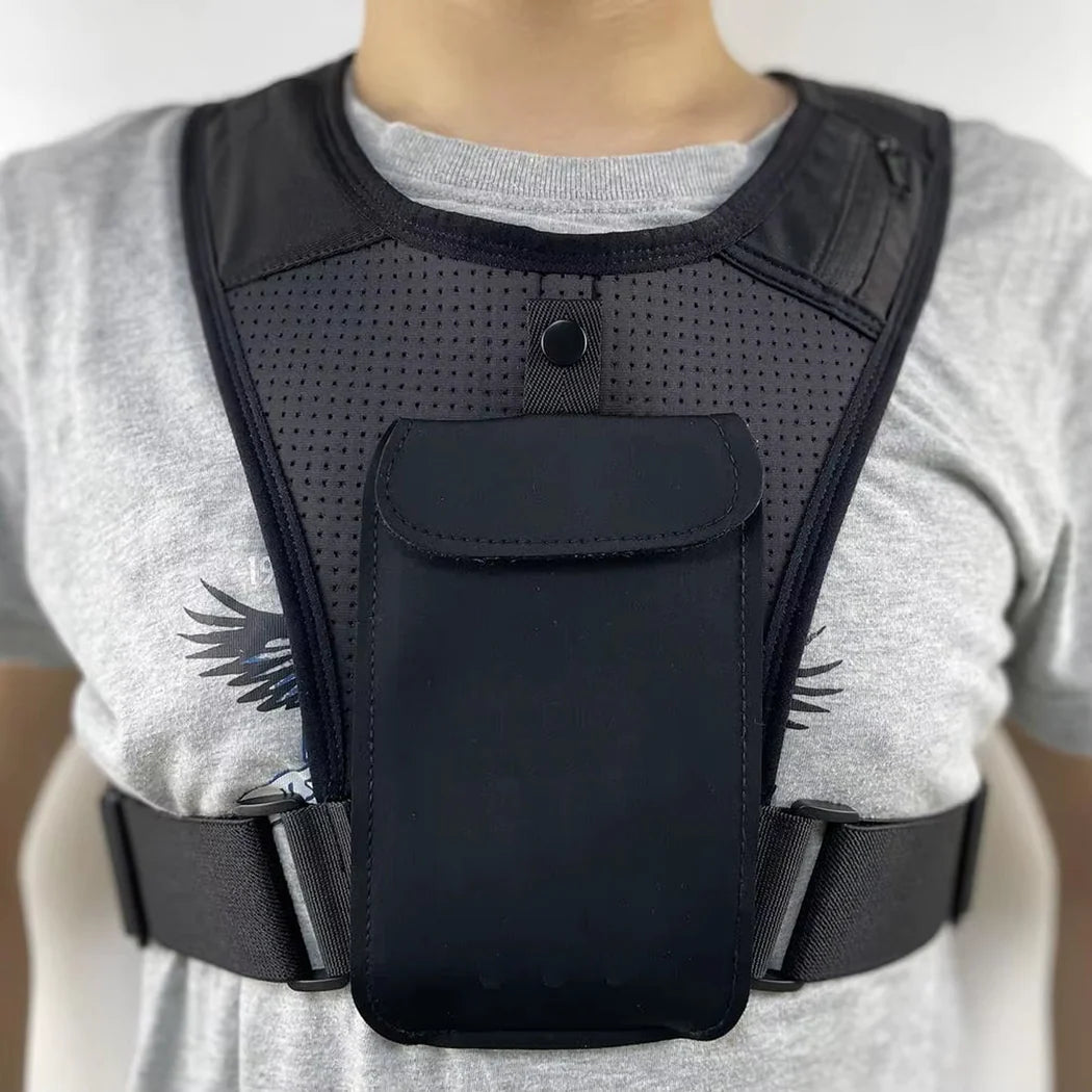 Black tactical vest worn by a person on a plain background