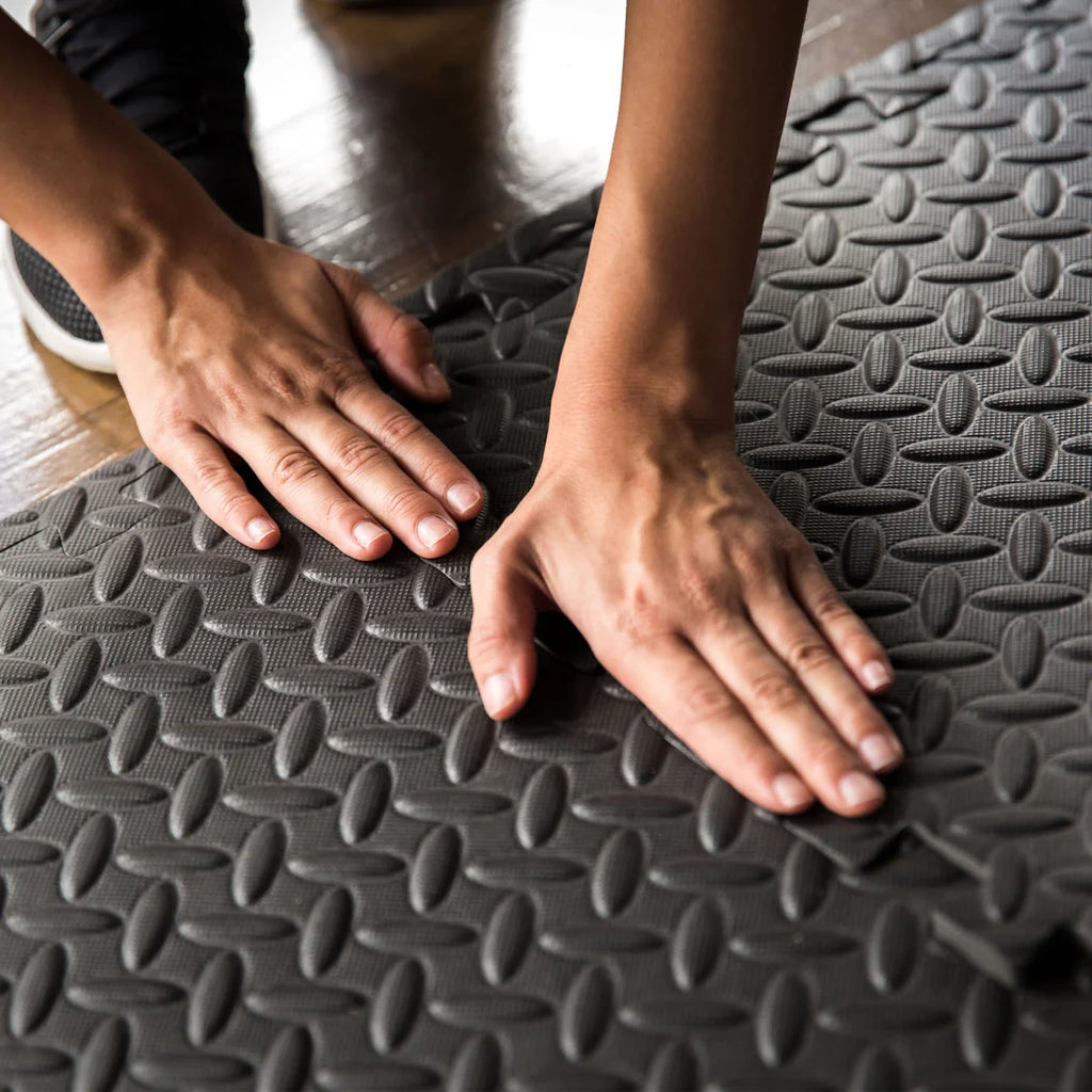 Person touching a textured gray mat with their hands