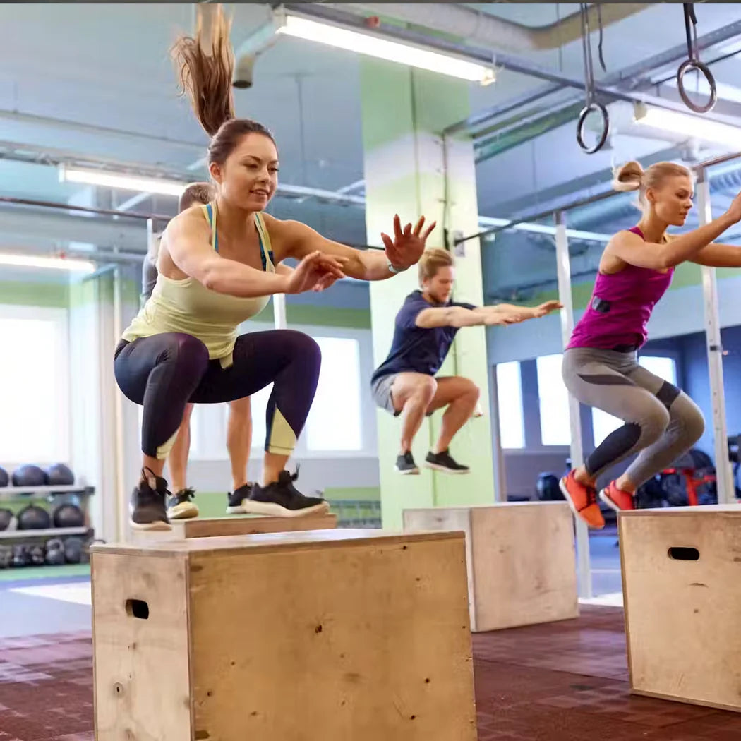Group of people exercising on boxes in a gym setting