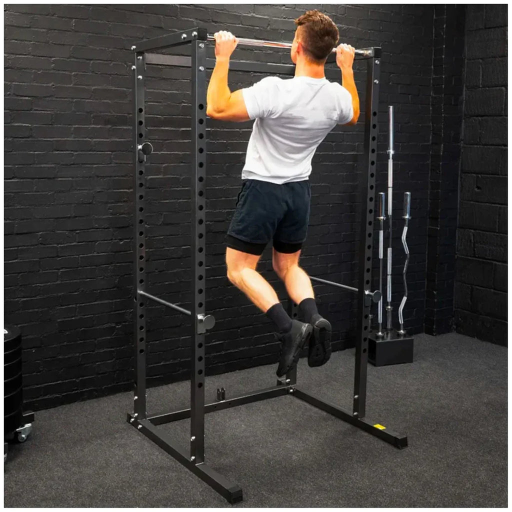 Person using a pull-up bar in a home gym setting.
