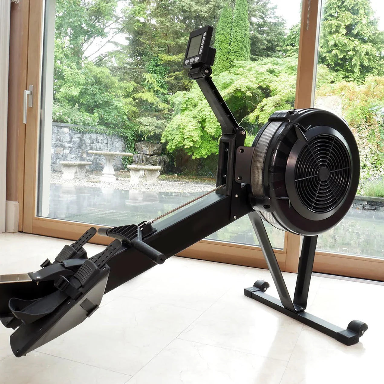 Rowing machine indoors with a view of greenery outside