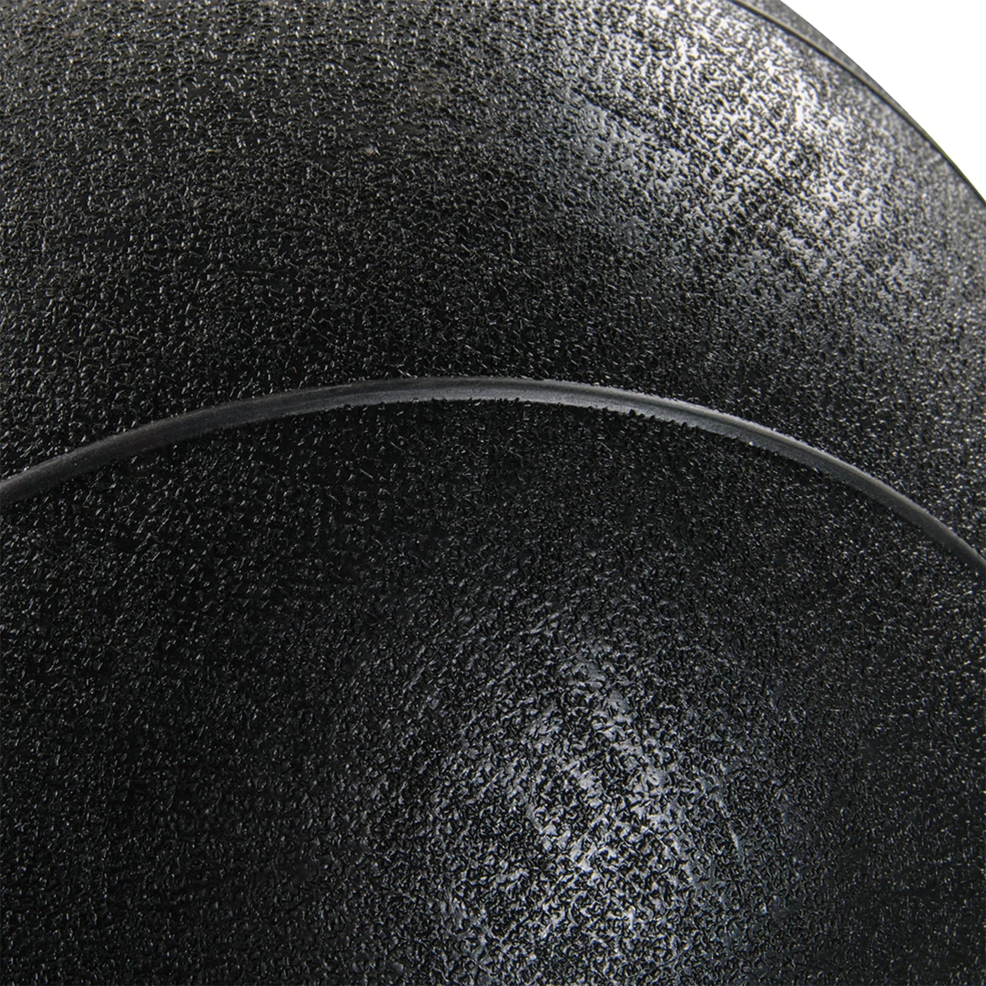 Close-up of a textured black surface with a curved line