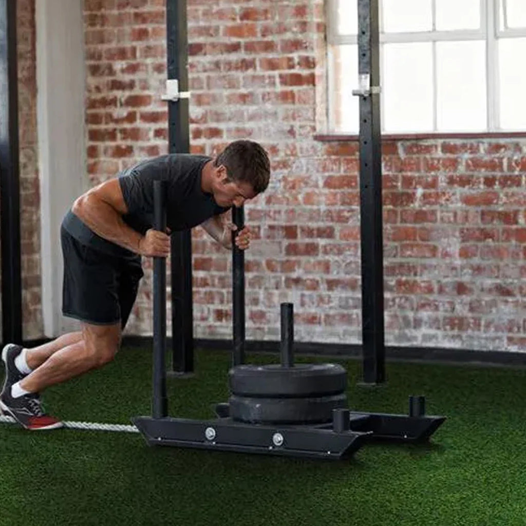 Person using a weight training machine in a gym setting with brick walls.