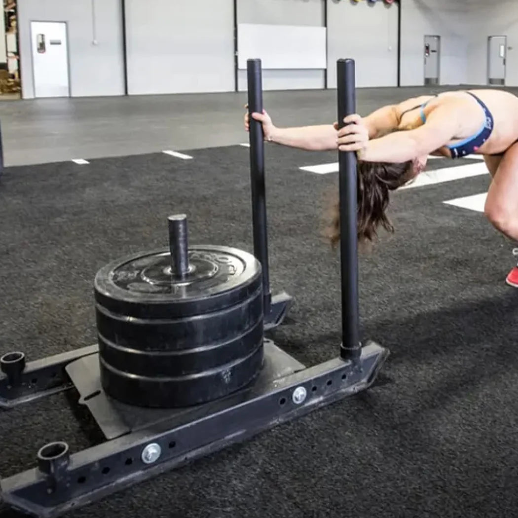 Person using a weight sled in a gym setting