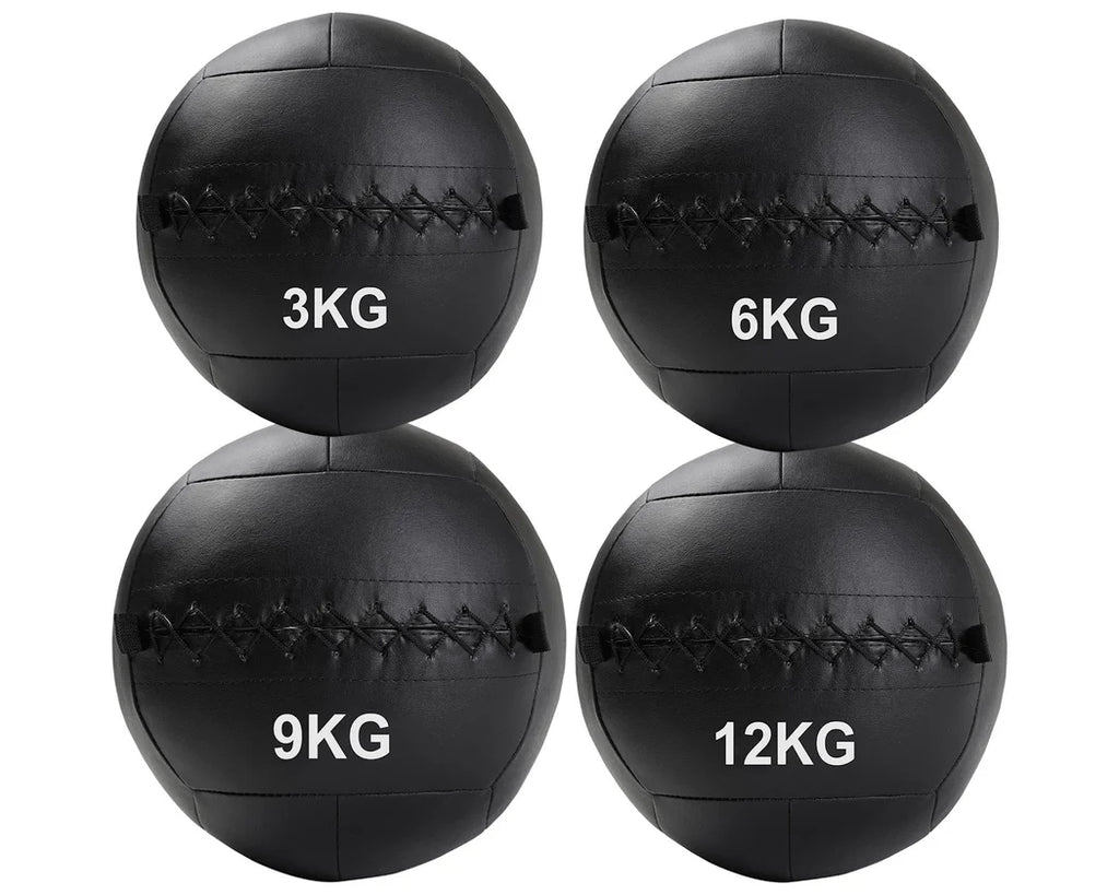 Four black wall balls with weight markings on a white background