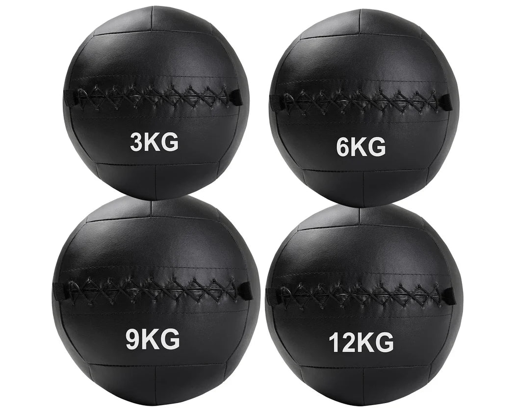 Four black wall balls with weight markings on a white background